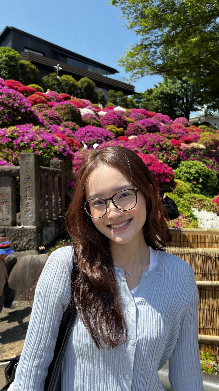 Photo of Amanda smiling in front of blooming azaleas